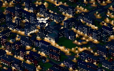 The town at night with lit windows and street lamps.
